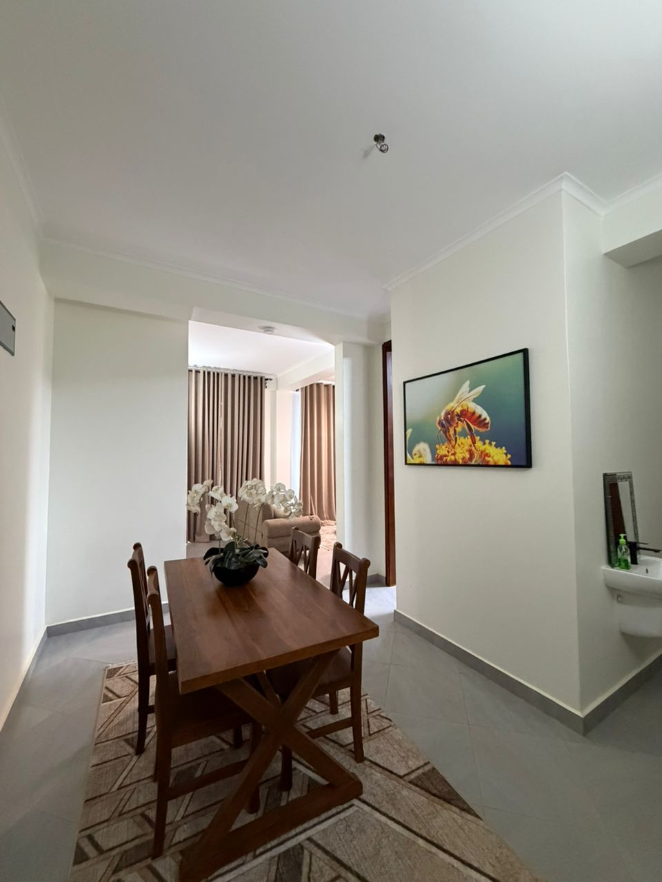 Double Hill Apartments elegant dining area with wooden table and chairs leading to living room